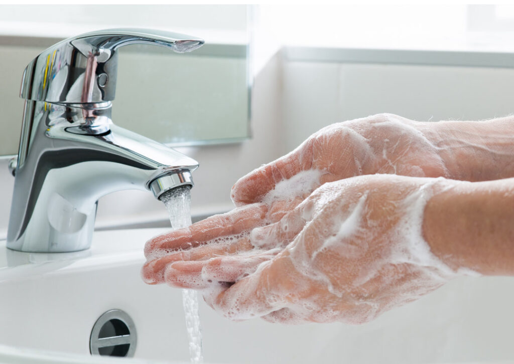 Foto für Blog Beitrag ELHADO Im Winter richtig heizen. Hände mit Seife, die unter einen fließenden Wasserhahn gehalten werden